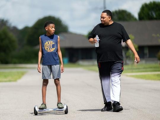  Joey Richard and his son Dylan, 12, chat as they walk and roll down to their neighborhood mailboxes Monday, June 1, 2026, in Sunset, La. Dylan will enter 6th grade this fall at Helix AI and Medical Academy.  STAFF PHOTO BY LESLIE WESTBROOK 