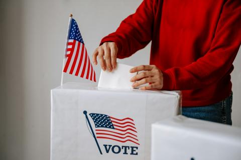Placing ballot in voting box.